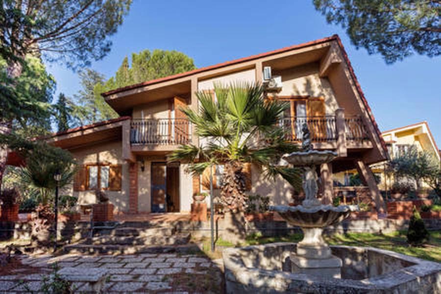 una casa grande con una fuente frente a ella en Etnachalet casa vacanze, en Belpasso