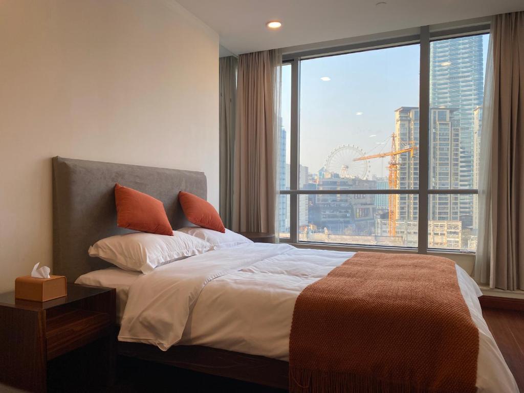 a bedroom with a bed and a large window at River House Near The Peoples Square And The Bund in Shanghai