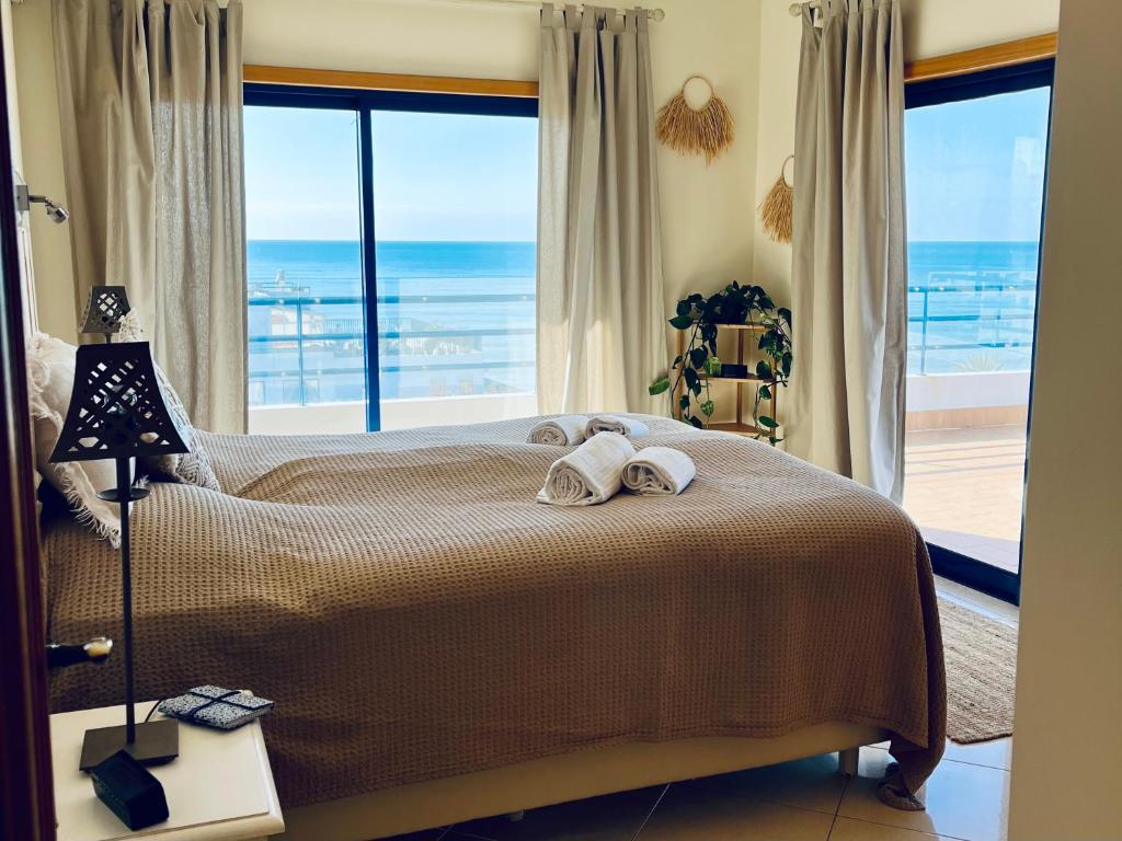 1 dormitorio con 1 cama y vistas al océano en Pérola do Algarve en Quarteira