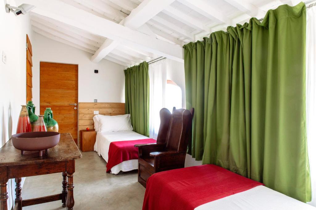 1 dormitorio con 2 camas y cortinas verdes en Podere Castellare, en Pelago