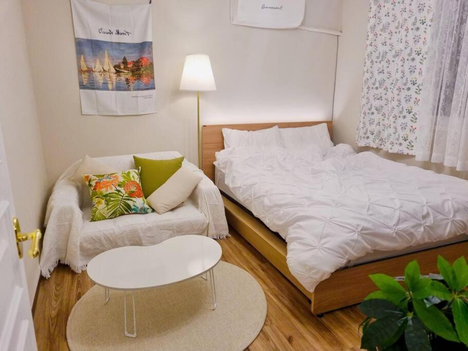 a small bedroom with a bed and a chair at Jamsil Heaven in Seoul