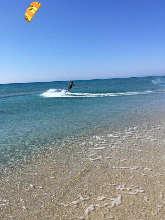 un hombre está haciendo kitesurf en el océano en la playa en Dionisos Roses, en Paralia Dionisiou