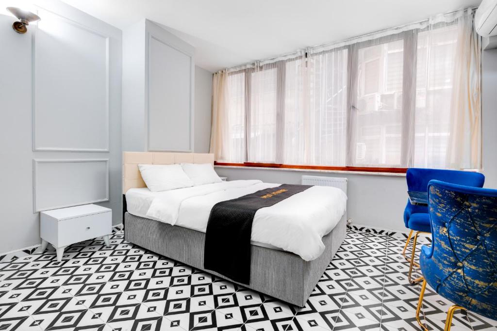 ein Schlafzimmer mit einem Bett und einem blauen Stuhl in der Unterkunft Portist Hotel in Istanbul