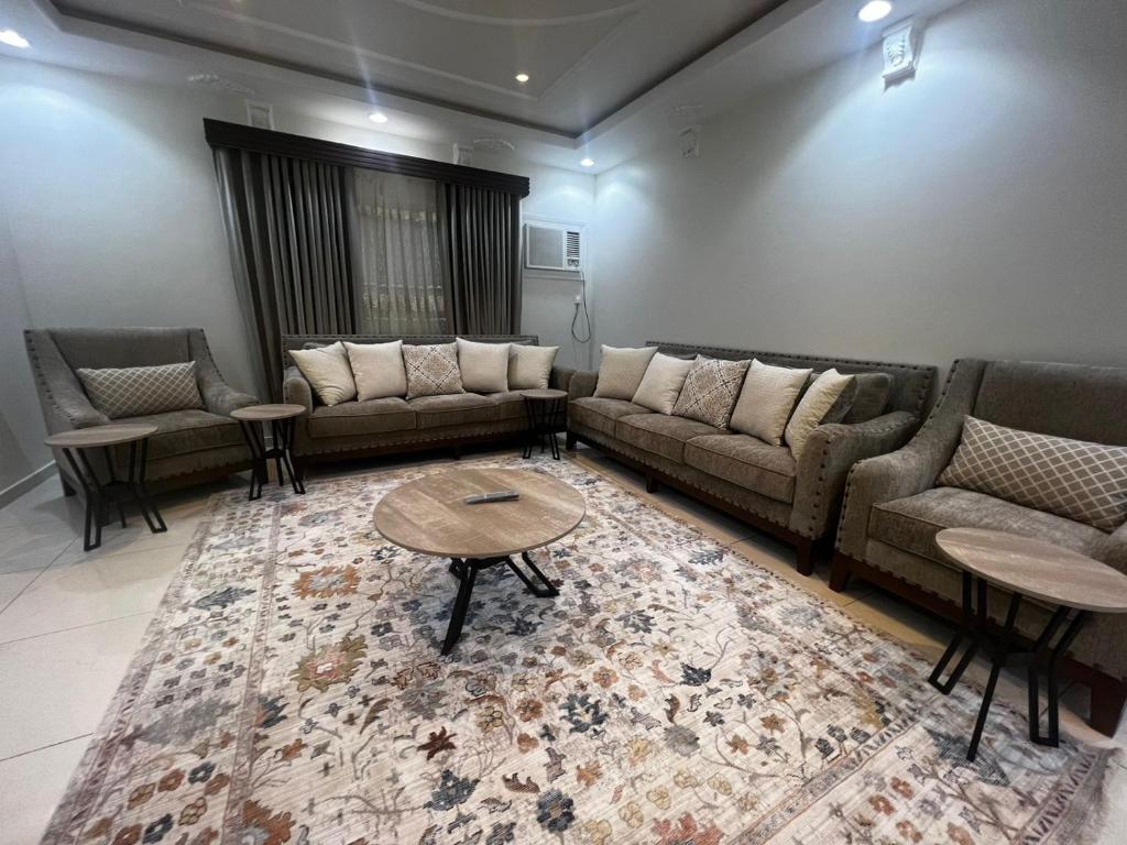 uma sala de estar com sofás, uma mesa e um tapete em 8 Luxury housing شقة فاخر em Medina