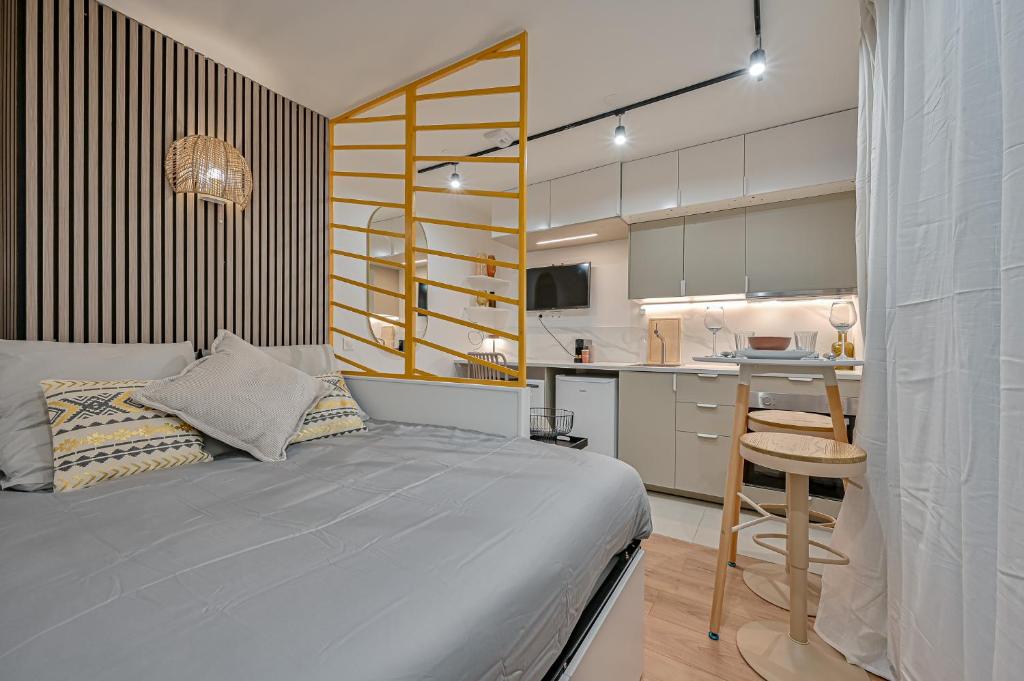 um quarto com uma cama, uma secretária e uma cozinha em Studio Parisien em Paris