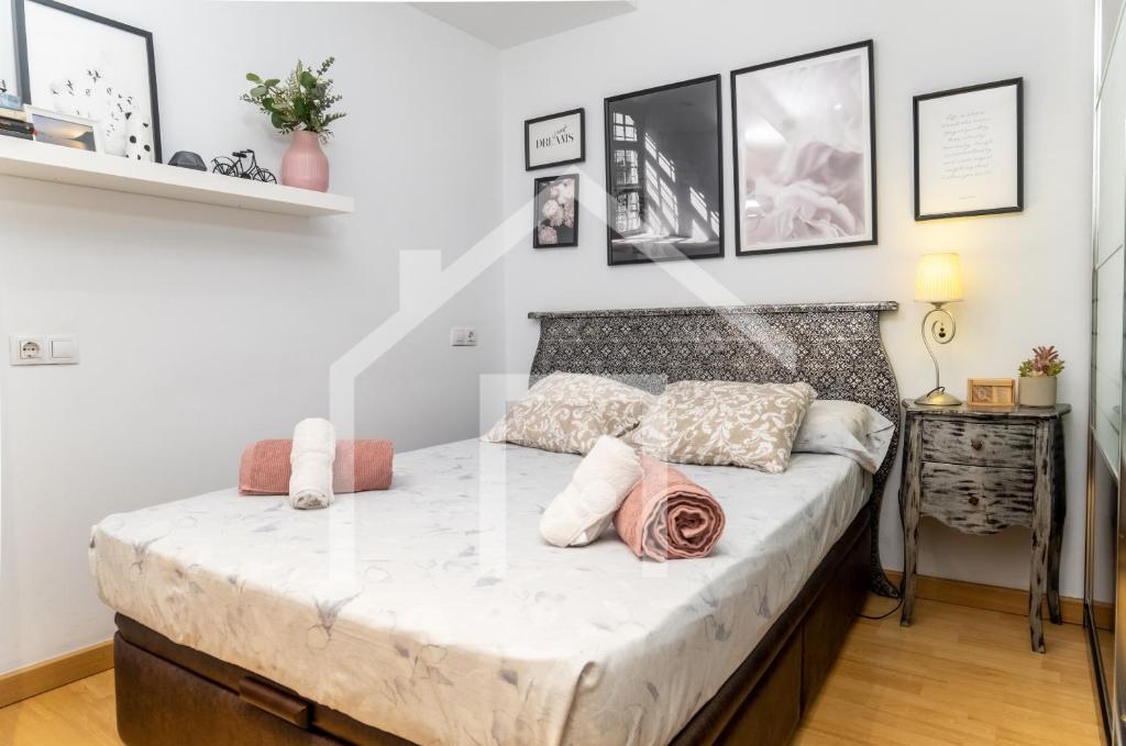 ein Schlafzimmer mit einem Bett mit weißen Laken und Kissen in der Unterkunft Loft Arco de los zapatos,Casco histórico Oviedo in Oviedo