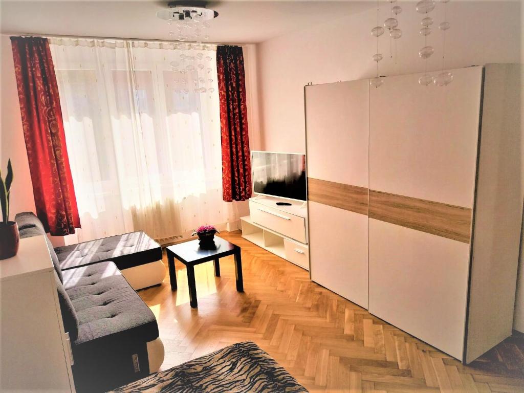a living room with a large white cabinet and a television at Útulný pokoj pro 1 osobu ve sdíleném bytě se ženou in Prague