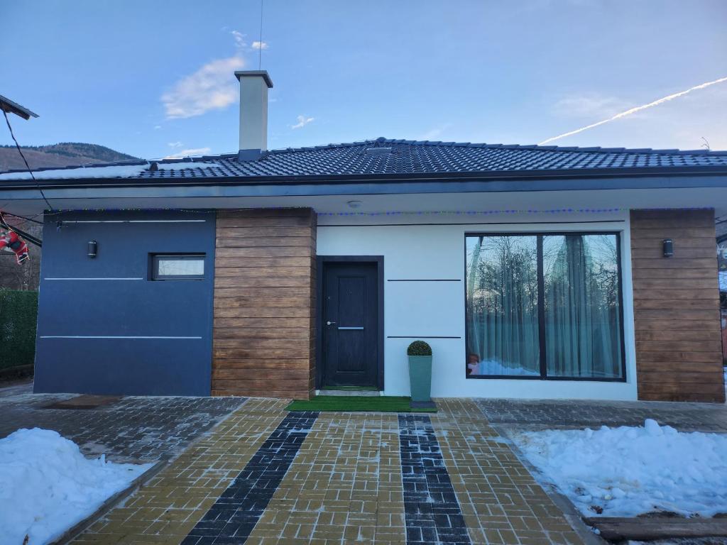 a house with a blue door and snow at Къща за гости Vip House 