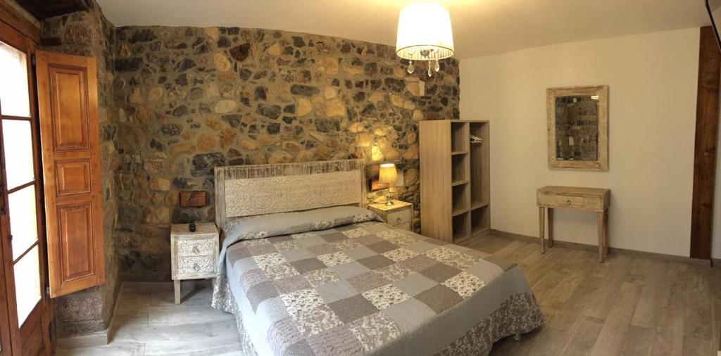 um quarto com uma cama e uma parede de pedra em Pensión San Pelayo 10 em Cangas de Onís