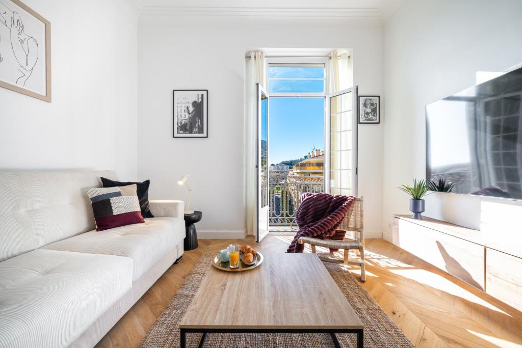un salon avec un canapé blanc et une table dans l'établissement MAJESTIC - Somptueux studio en plein coeur de Menton, à Menton