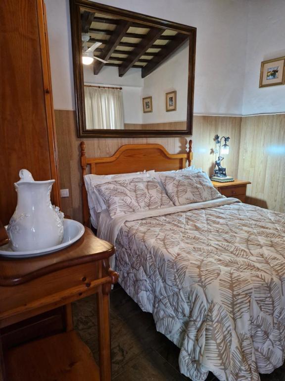 1 dormitorio con cama y espejo en una mesa en Casa Museo Jerez Centro, en Jerez de la Frontera