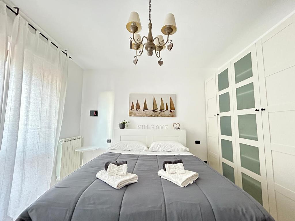 a bedroom with a large bed with two towels at Nui Prestige Home in Fiumicino