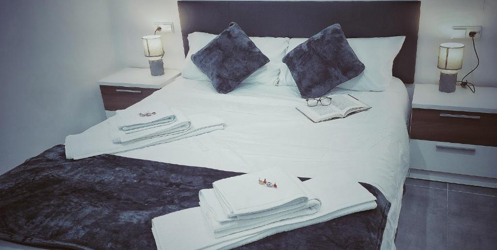 Una cama blanca con toallas y almohadas. en Apartamento La Paz, en Torrellano