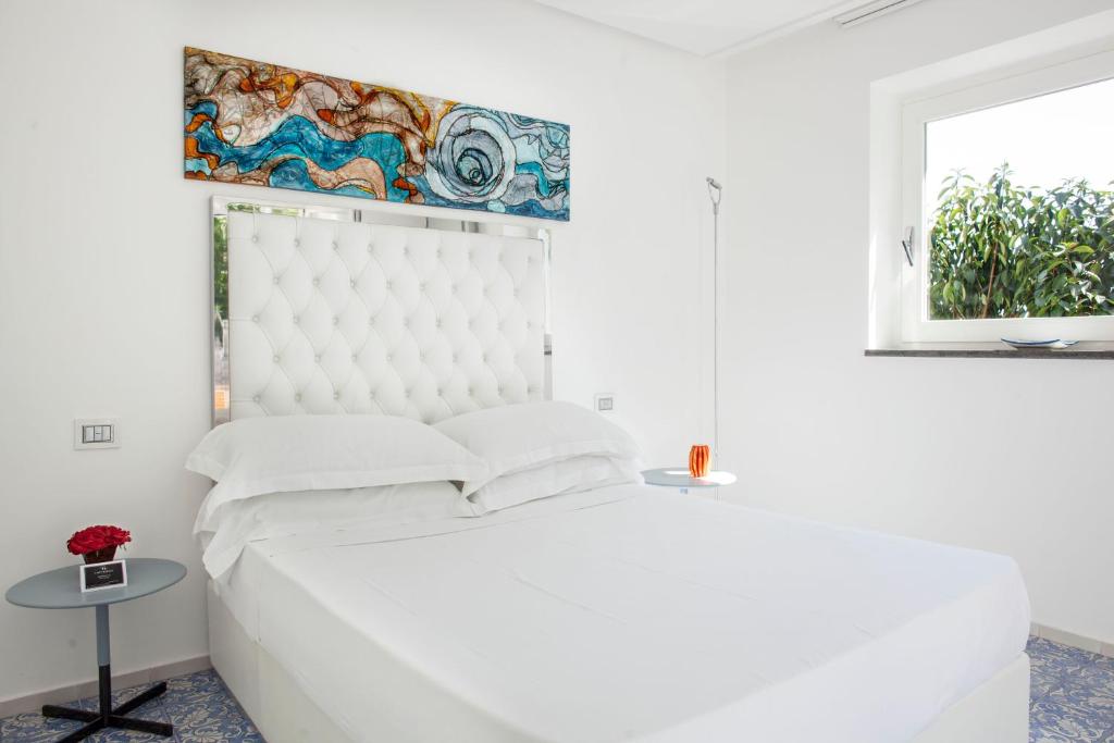 a white bedroom with a large bed and a window at LHP Suite Superior Cottage Capri in Capri