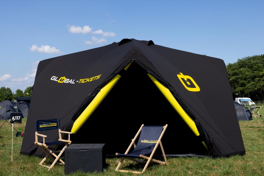 two chairs and a black tent with two chairs at TT Camping Jan & Bertha - by Global-Tickets in Assen
