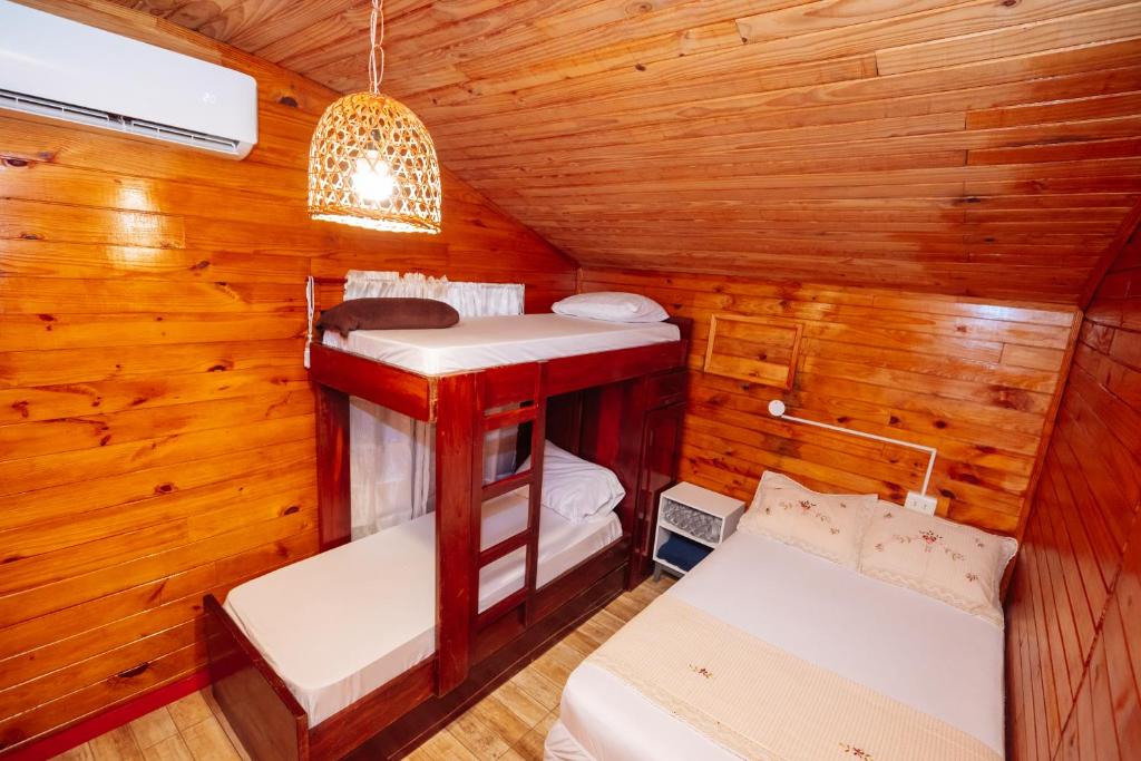 a room with two beds in a wooden cabin at Cabin Renty Beach in Encarnación