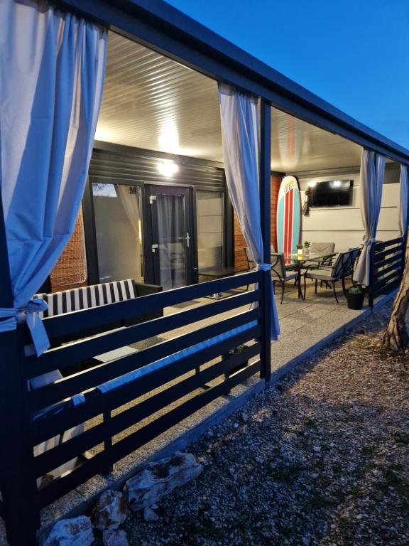 Casa con cortinas azules y patio en Mobile home Mia en Privlaka