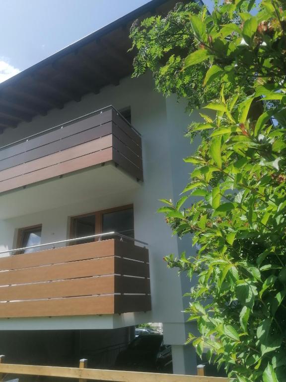 a building with a wooden balcony and trees at Apartment Eberharter in Mayrhofen
