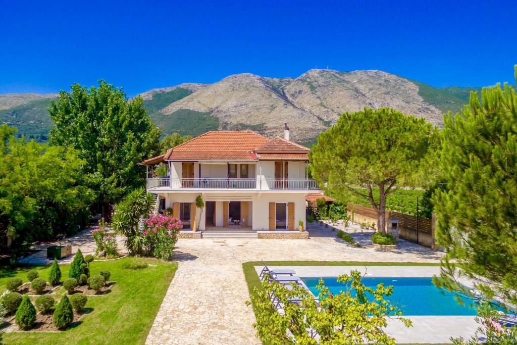 a house with a swimming pool and mountains in the background at Villa Agricola in Alykes