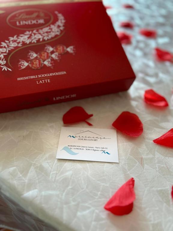 a card sitting on top of a box with red roses at Mareincasa Dimora Luxury in Polignano a Mare