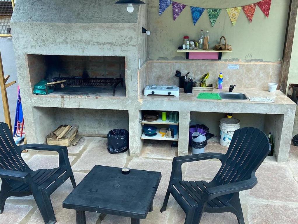 two chairs and a table in a kitchen with a fireplace at La Casita Yogui - MONOAMBIENTE 1 in Santa Rosa de Calamuchita