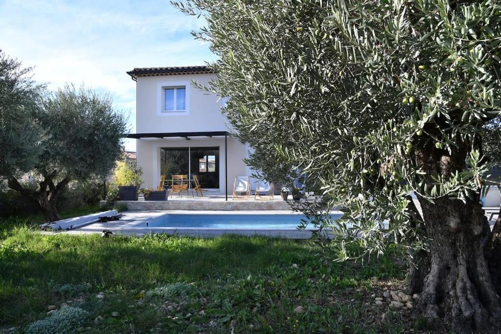 uma casa com piscina no quintal em Villa Le Clos des Oliviers em LʼEscale