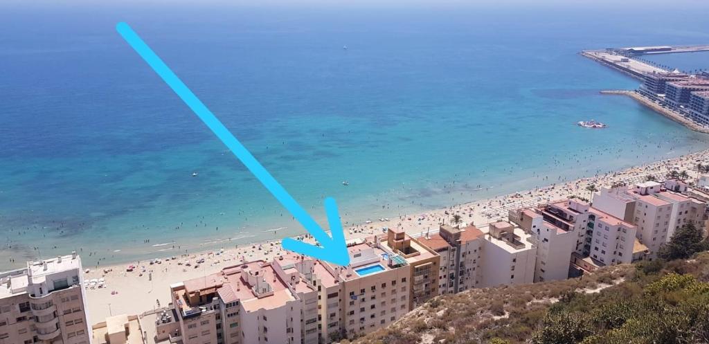 Una vista de una playa con edificios y el océano. en UNIQUE APT. W/POOL- ACROSS THE BEACH-WIFI-A/C, en Alicante