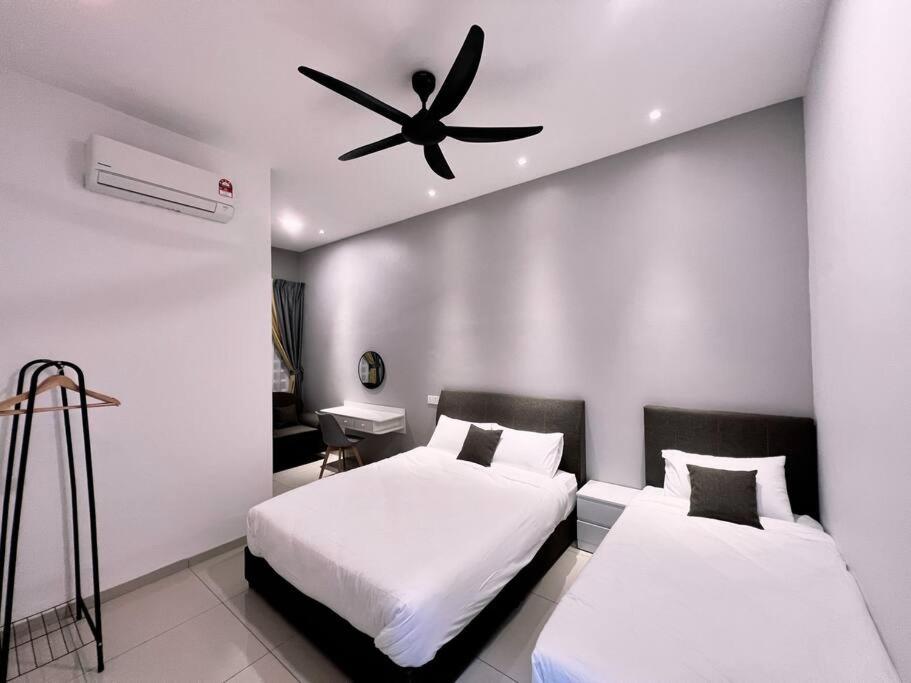 a bedroom with two beds and a ceiling fan at [New Double Storey] 12 to 14 Pax - SG ABONG - BRIGHT INN HOMESTAY in Muar
