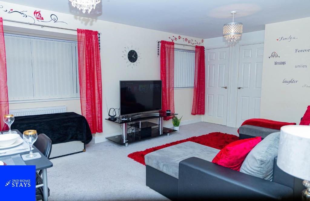 a living room with red curtains and a tv at 2ndHomeStays-West Bromwich- 2-Bedroom Maisonette in West Bromwich