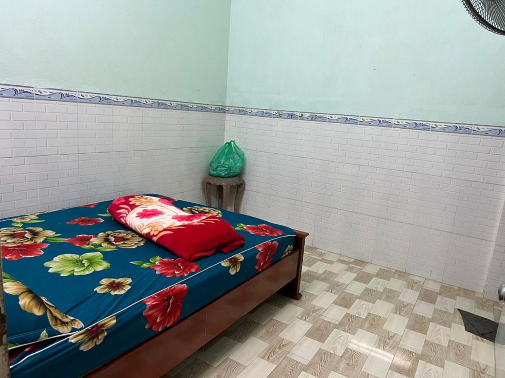 - une chambre dotée d'un lit avec un couvre-lit bleu et rouge dans l'établissement Nhà Nghỉ SAM SILK, à Quy Nhơn