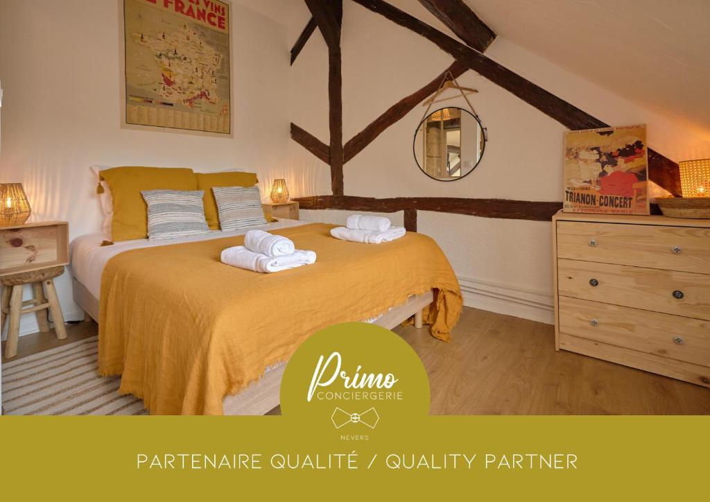 een slaapkamer met een bed met handdoeken erop bij "Le Beffroi" cocon en hyper centre de Nevers, service premium by PRIMO C0NCIERGERIE in Nevers