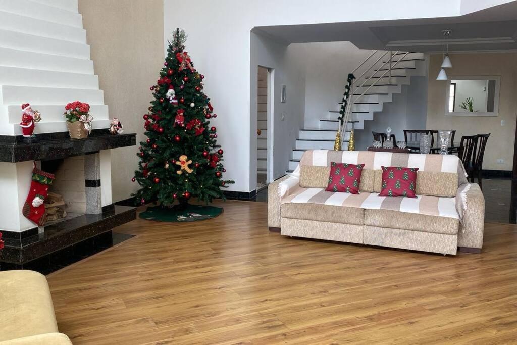 a living room with a christmas tree and a couch at Sobrado espaçoso em Santa felicidade in Curitiba