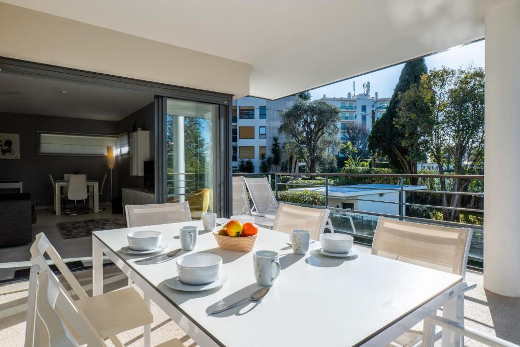 comedor con mesa blanca y sillas en SERRENDY 2-bedroom- with terrace & pool, en Cannes
