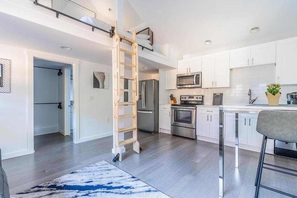 uma cozinha com armários brancos e uma escada em Cute as a Button! em Seattle