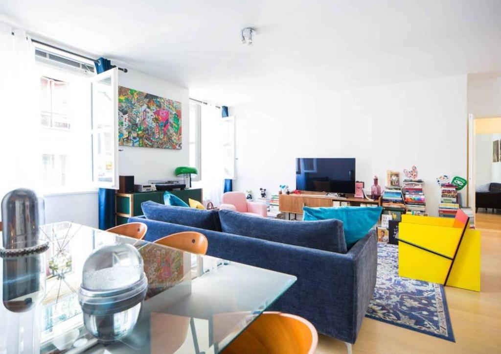 a living room with blue couches and a glass table at The Beauty of Venice in Paris