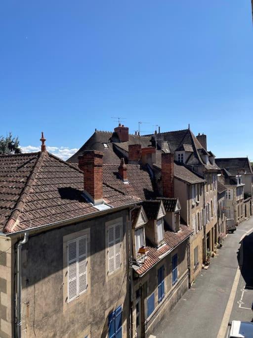 una fila di case con tetti su una strada cittadina di Appartement Notre Dame 2 a Montluçon