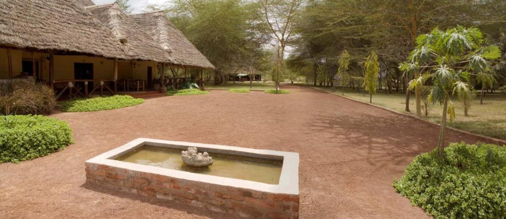 un patio con una fuente frente a un edificio en NSYA CAMP MANYARA en Mto wa Mbu
