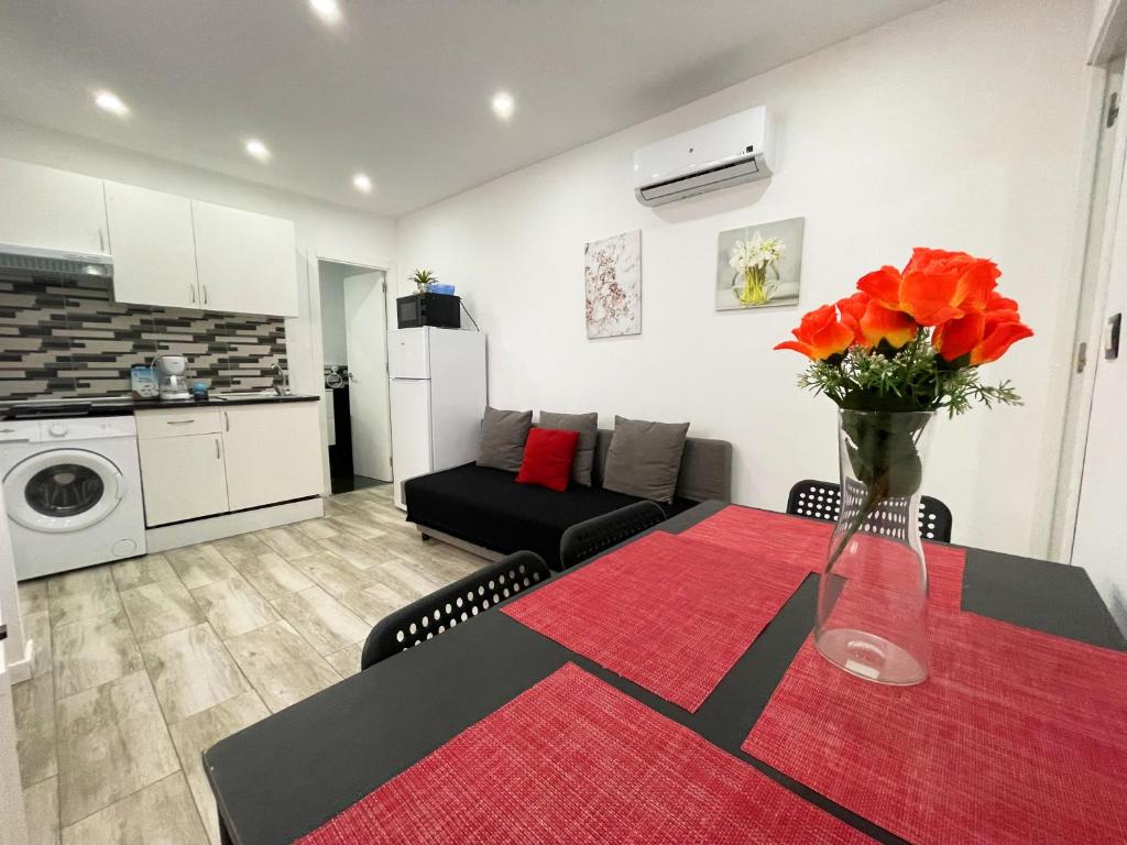 a living room with a table with a vase of flowers at Apartments near metro in Madrid