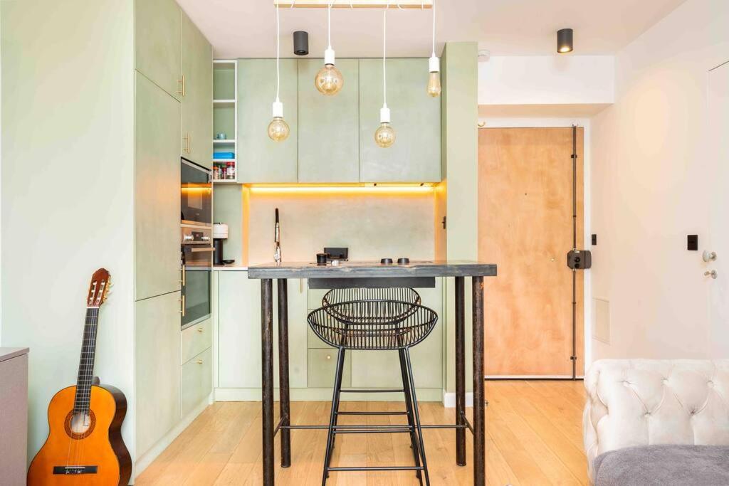 cocina con mesa y guitarra en una habitación en Superbe appartement refait au centre de Clamart, en Clamart