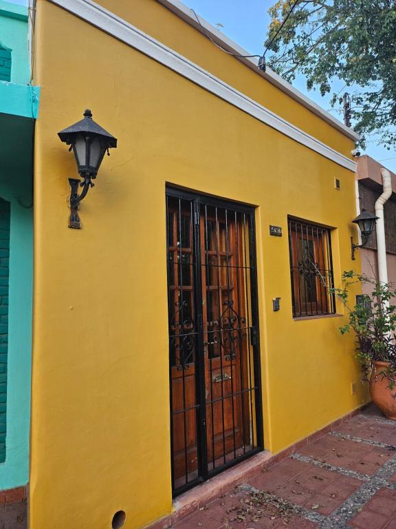 un bâtiment jaune avec une porte et un éclairage de rue dans l'établissement Martinolli5130, à Córdoba