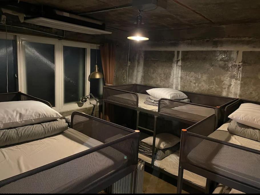 a room with three bunk beds and a window at How are you here in Hongdae in Seoul