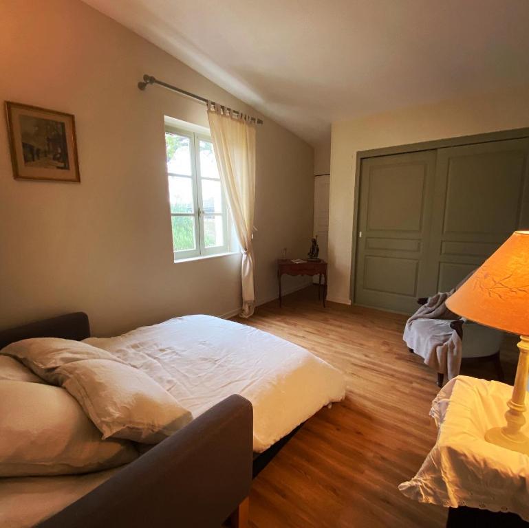 a bedroom with a large bed and a window at Le Clos Boissière - Gîte Cosy in Valence-sur-Baïse