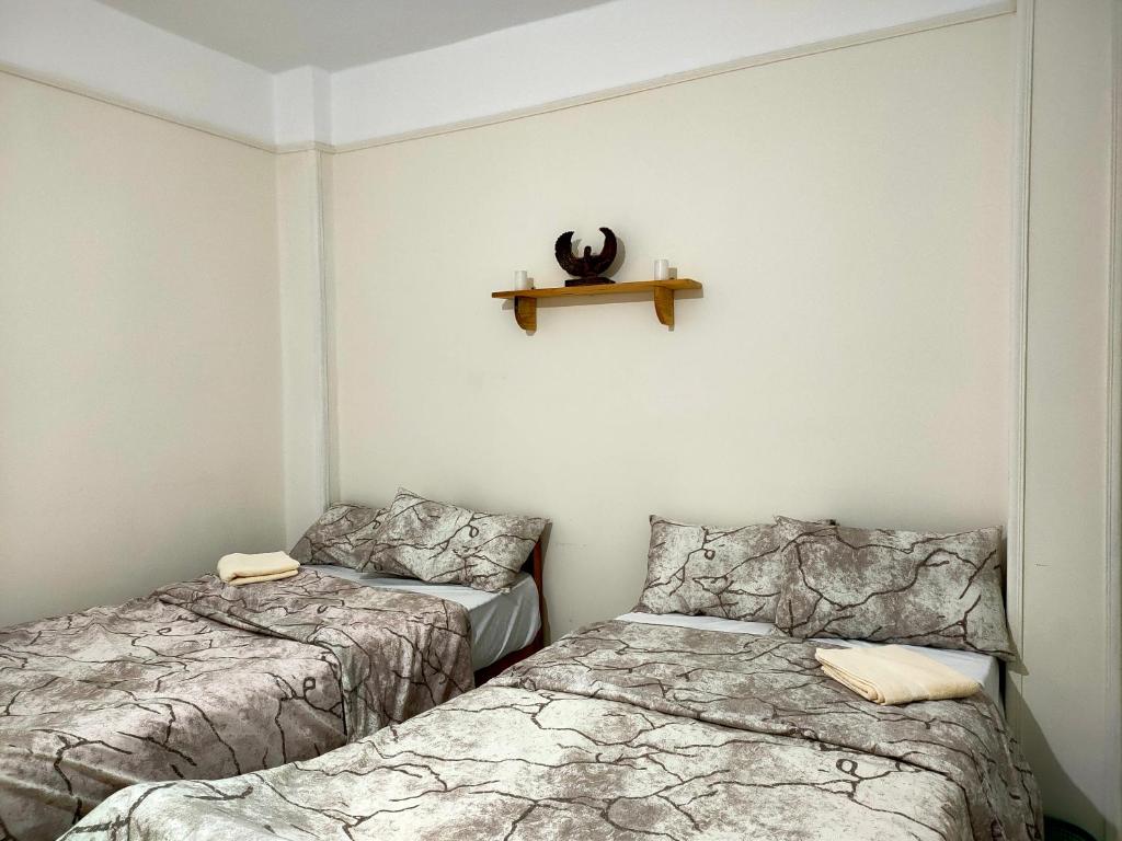 two beds in a room with a shelf on the wall at Kemet - a private room at Shared apartment For Men only No Ladies allowed غرفة خاصة في شقة مشتركة للرجال فقط ممنوع السيدات in Alexandria