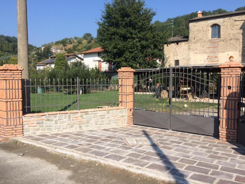 uma cerca com um portão com um cão por trás em C. Giarelli em Monti di Licciana Nardi