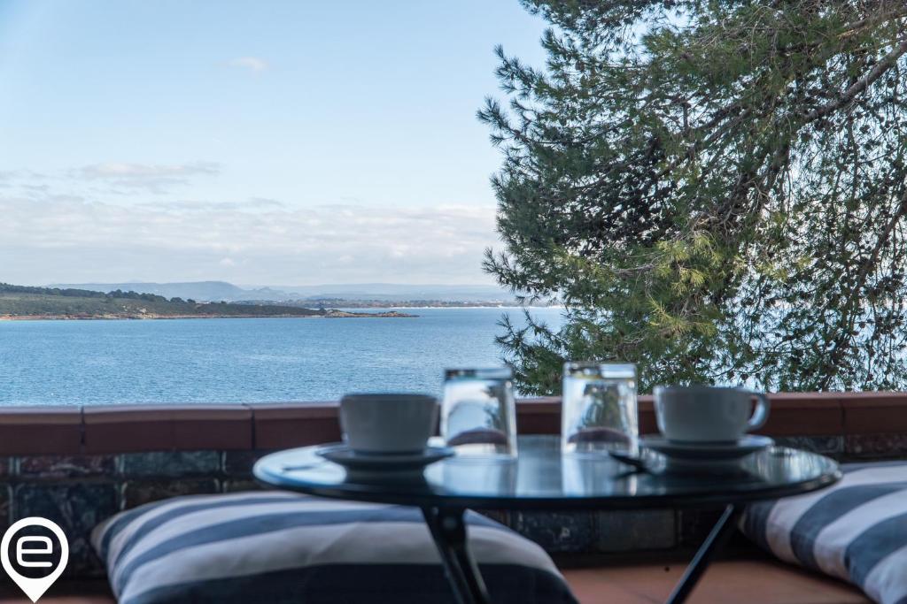 un tavolo con due tazze di caffè e una vista sull'acqua di Alghero Sea Whisper a Fertilia