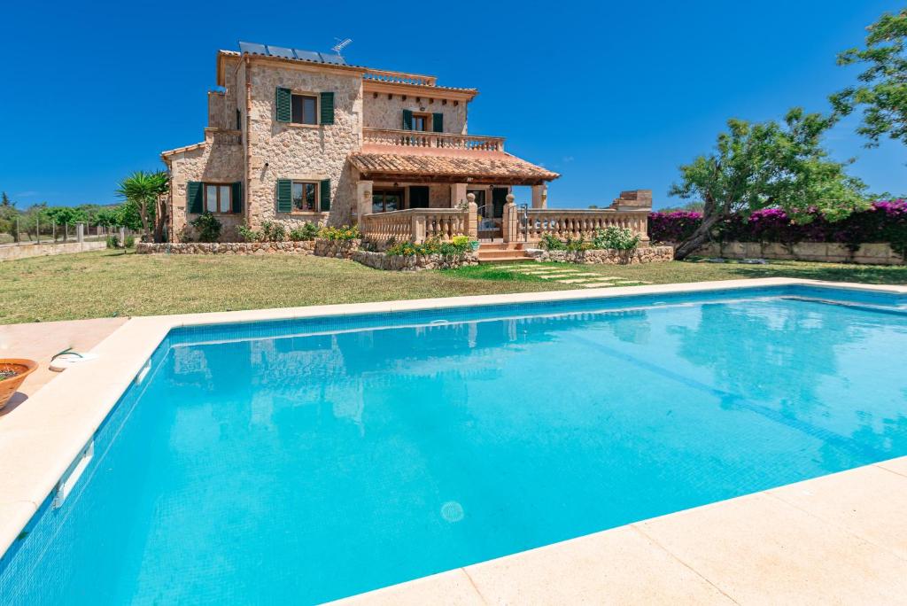 a villa with a swimming pool in front of a house at Villa Els Amatllers by Sealand Villas in Port de Pollensa