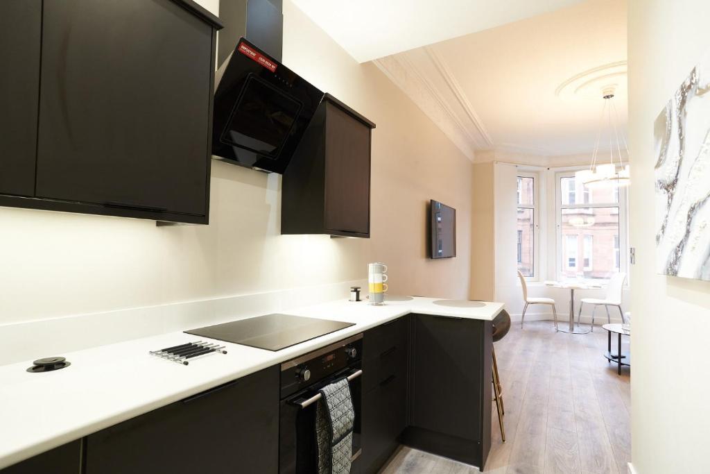 a kitchen with a sink and a counter top at Lovely, Recently Refurbished Two Bedroom Apartment in Glasgow