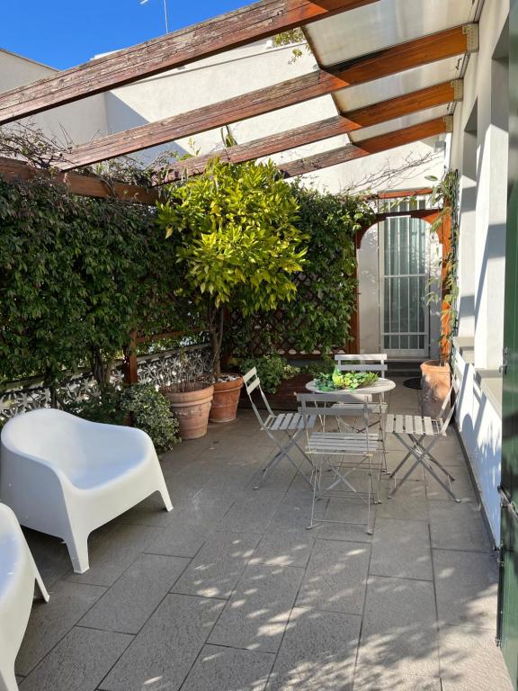 une terrasse avec une table, des chaises et des plantes dans l'établissement Casapenelope, à Mestre