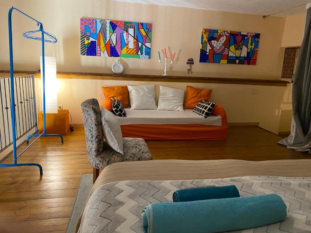 a room with a bed and a couch and paintings at Sakè Loft in Catania