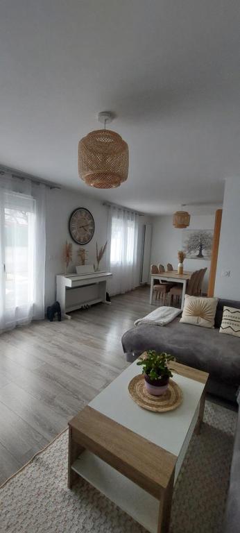 ein Wohnzimmer mit einem Sofa und einem Tisch in der Unterkunft Maison individuelle avec jardin in Vaujours